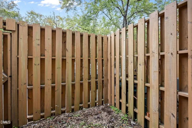 a view of a wooden fence with a yard