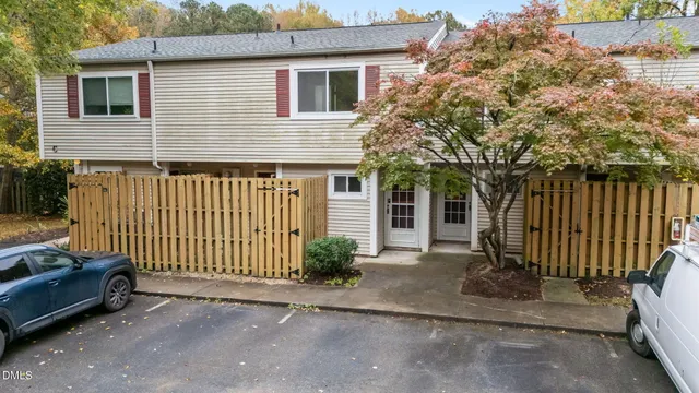 a view of a house with a small yard and wooden fence