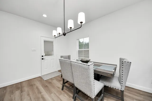 a view of a dining room with furniture and a chandelier