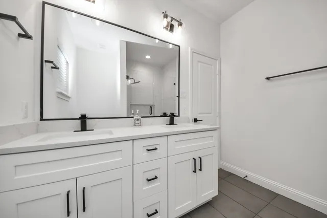 a bathroom with a double vanity sink and mirror