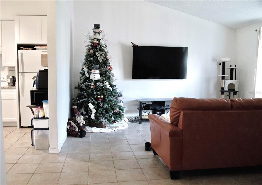 360 Cocoa Court Kissimmee, FL 34758 - Photo 5 of 11 a living room with furniture and a flat screen tv