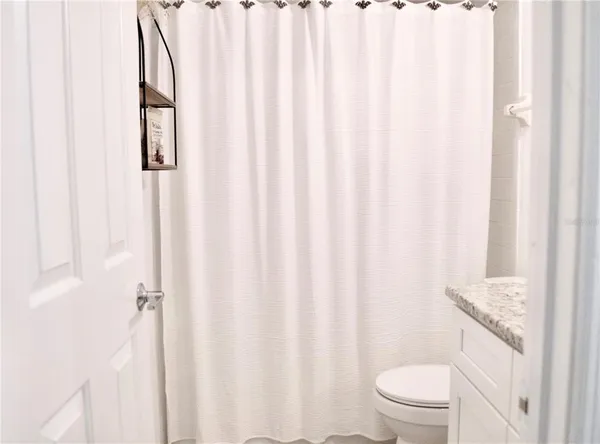 a white toilet sitting next to a shower curtain