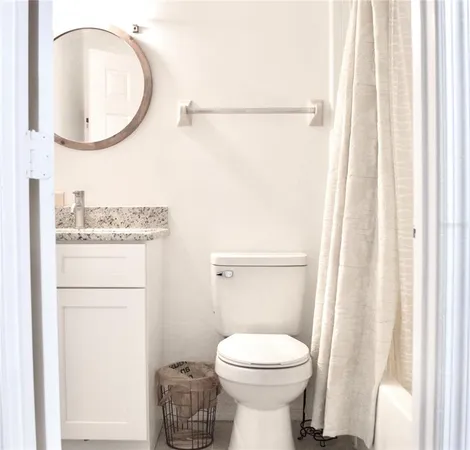 a bathroom with a toilet and a mirror