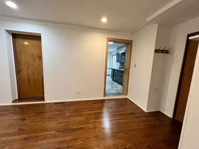an empty room with wooden floor and entrance