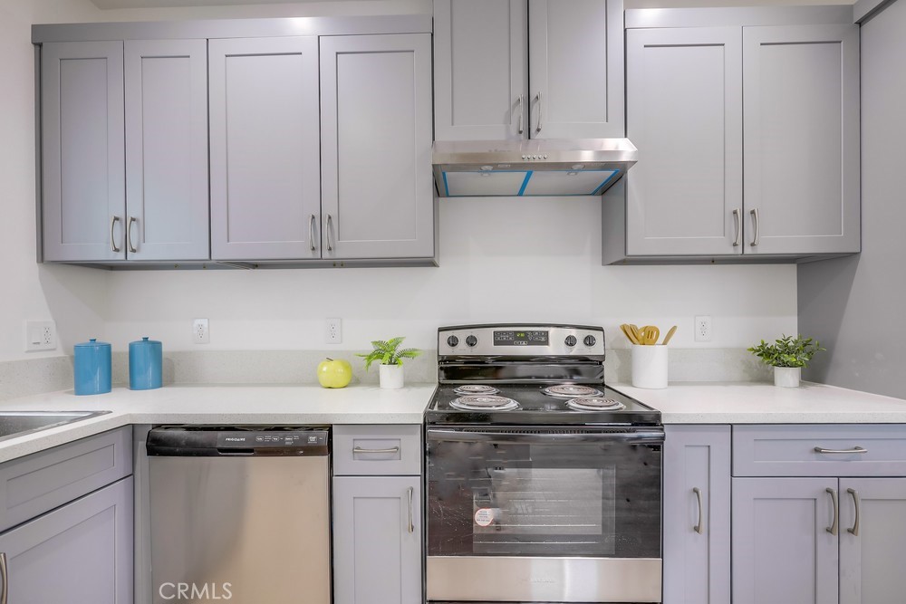 6439 Mohawk Road Westminster, CA 92683 - Photo 18 of 41 a kitchen with stainless steel appliances granite countertop a stove a white cabinets a green and a white wooden cabinets