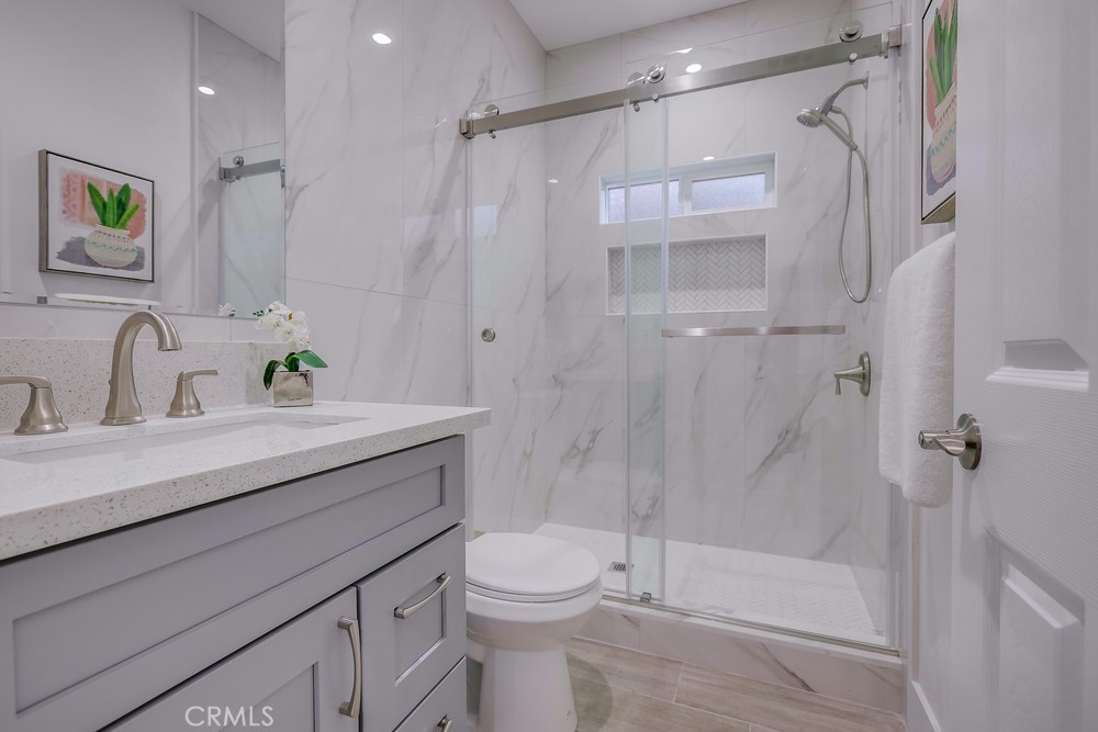 6439 Mohawk Road Westminster, CA 92683 - Photo 30 of 41 a bathroom with a shower sink vanity mirror and toilet