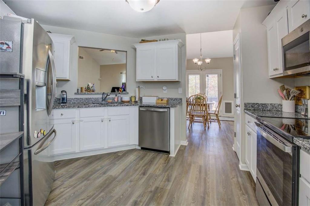 160 Savannah Way Milner, GA 30257 - Photo 2 of 41 a kitchen with stainless steel appliances granite countertop a refrigerator a stove top oven a sink dishwasher and wooden floor