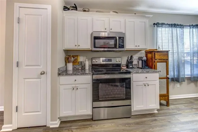 a kitchen with white cabinets and appliances