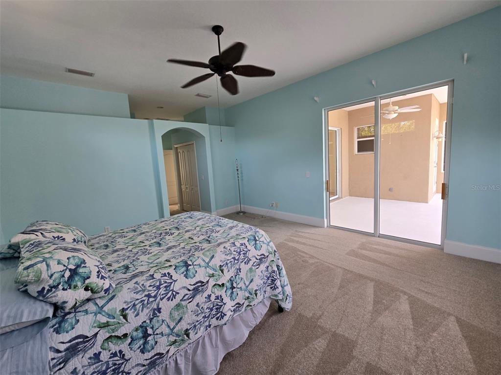 14970 Appleton Boulevard Port Charlotte, FL 33981 - Photo 18 of 48 a bedroom with a bed and a chandelier