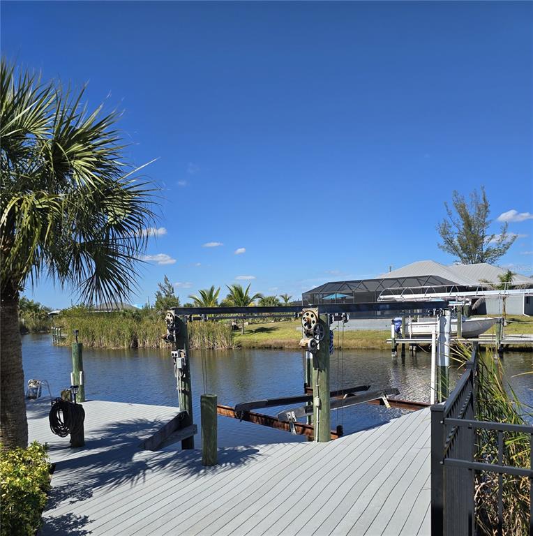 14970 Appleton Boulevard Port Charlotte, FL 33981 - Photo 47 of 48 a view of a patio with table and chairs under an umbrella with wooden floor