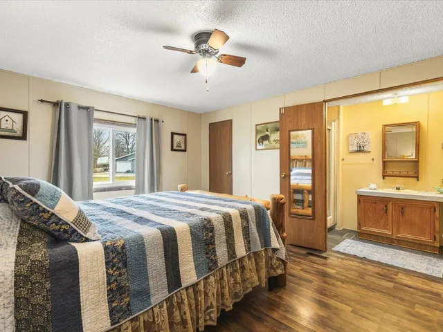 a bedroom with a large bed and wooden floor