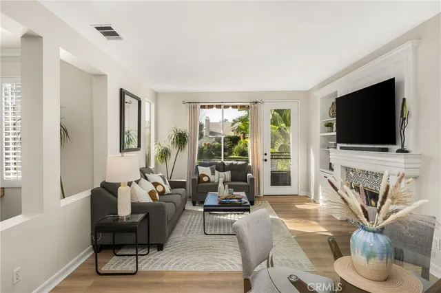 a living room with furniture a flat screen tv and a fireplace