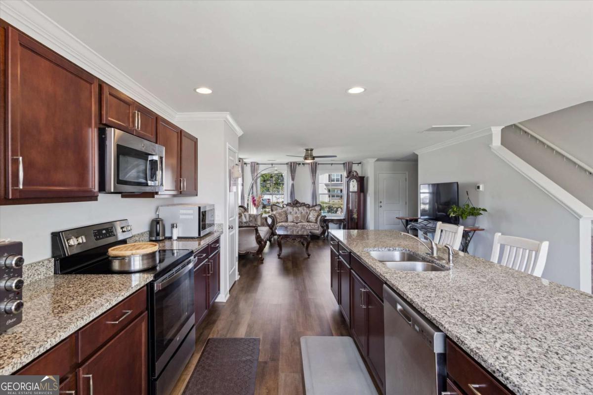 455 Tondee Way Midway, GA 31320 - Photo 12 of 52 a kitchen with granite countertop lots of counter top space a sink and appliances