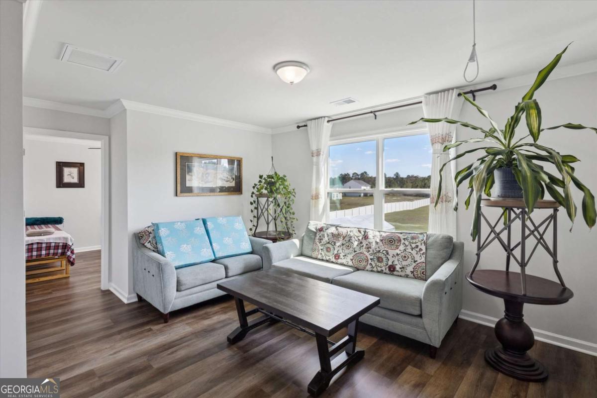 455 Tondee Way Midway, GA 31320 - Photo 16 of 52 a living room with furniture and a floor to ceiling window