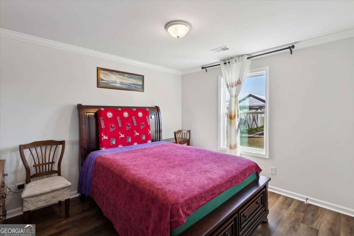 455 Tondee Way Midway, GA 31320 - Photo 25 of 52 a bedroom with a bed and a chair