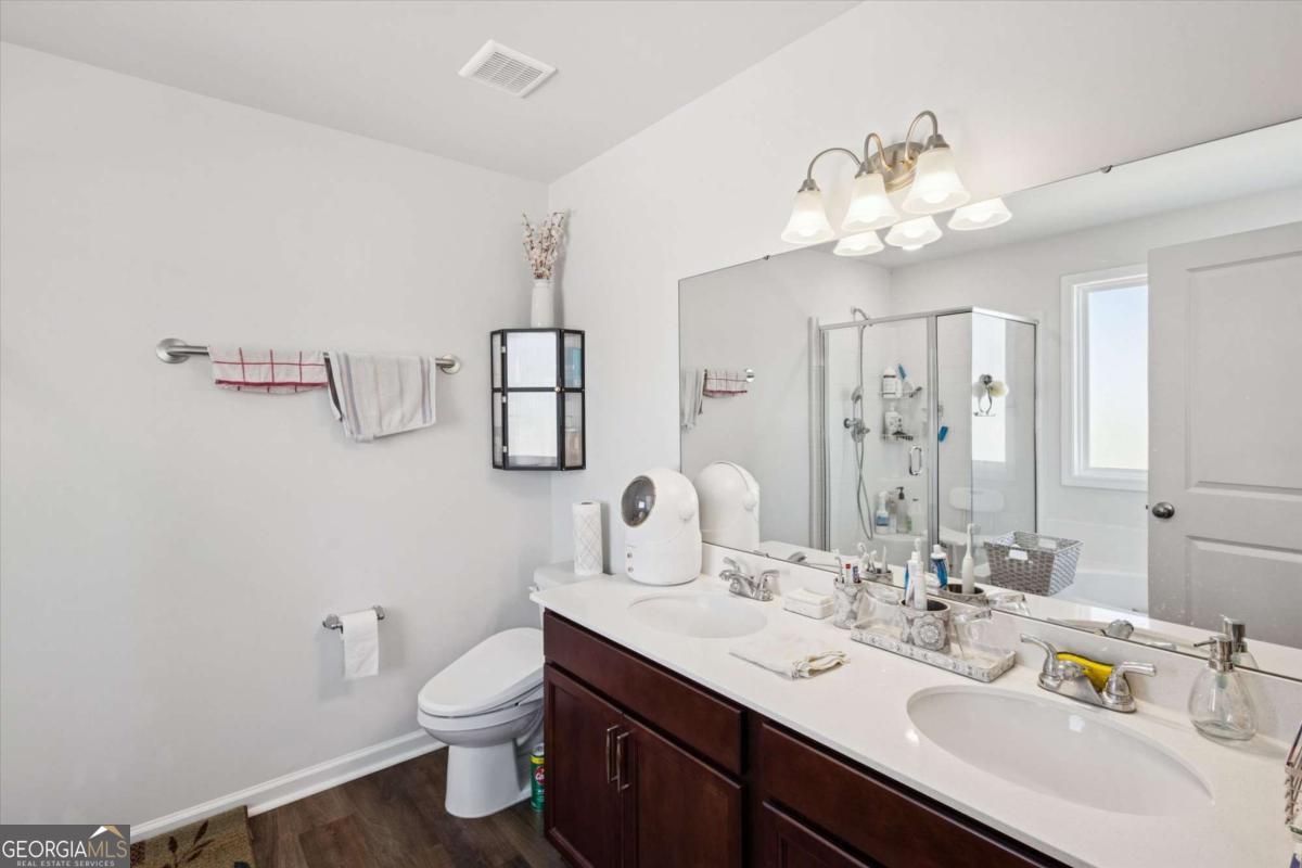 455 Tondee Way Midway, GA 31320 - Photo 30 of 52 a bathroom with a double vanity sink toilet and a mirror