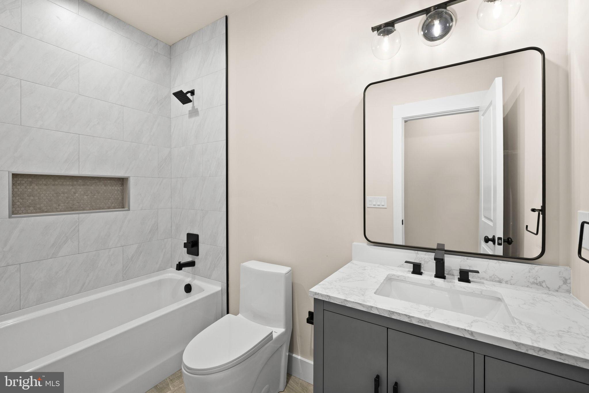 312 9th Street Colonial Beach, VA 22443 - Photo 12 of 59 a bathroom with a toilet sink vanity tub and shower