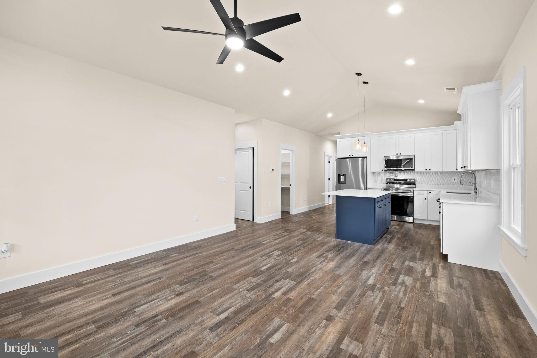312 9th Street Colonial Beach, VA 22443 - Photo 54 of 59 a kitchen with stainless steel appliances kitchen island wooden floors and view living room