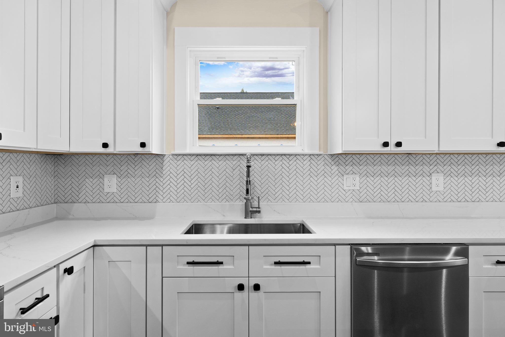 312 9th Street Colonial Beach, VA 22443 - Photo 58 of 59 a kitchen with white cabinets and a sink