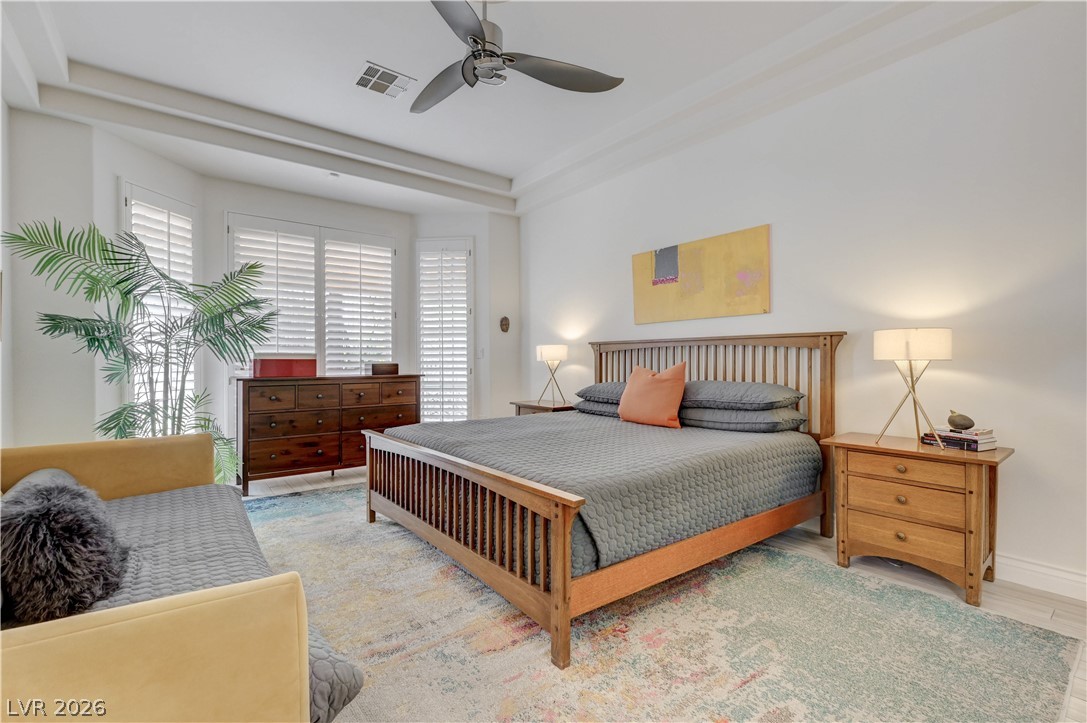 457 Indigo Springs Street Henderson, NV 89014 - Photo 18 of 58 Primary bedroom with tray ceiling and fan.