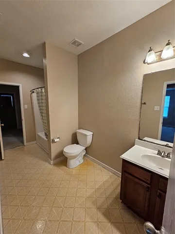 a bathroom with a sink mirror vanity and toilet