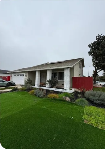 a view of a house with backyard and sitting area