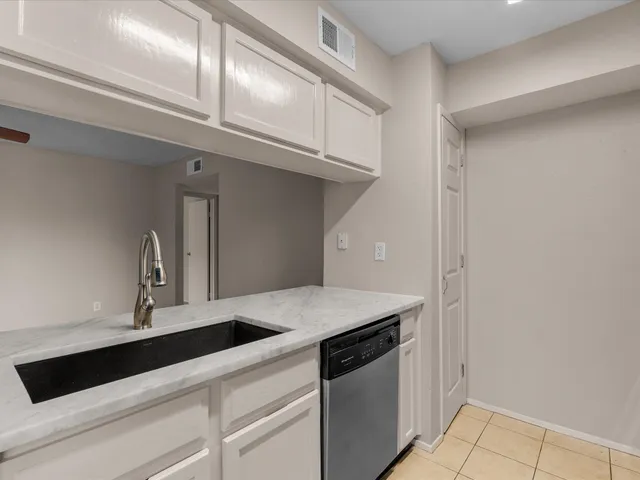 a kitchen with a sink a counter top space cabinets and stainless steel appliances