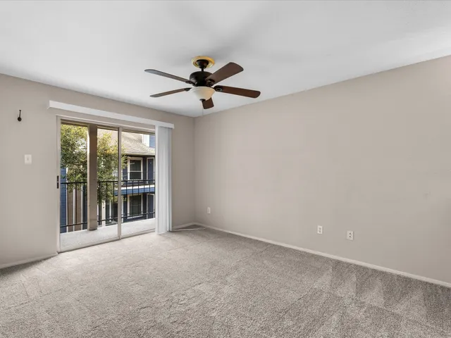 a view of a livingroom with a ceiling fan and window