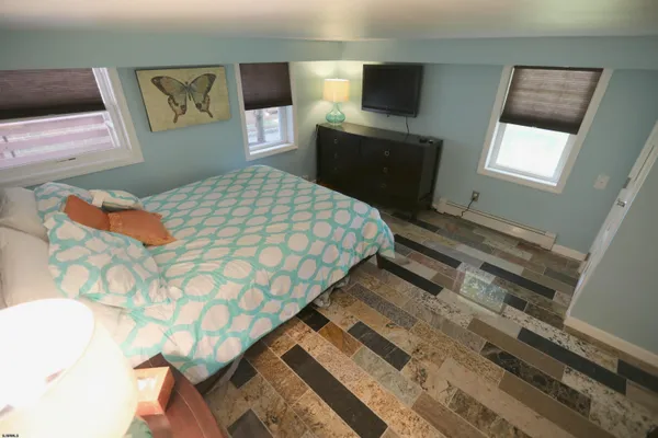 a bedroom with a bed and a tv on the dresser