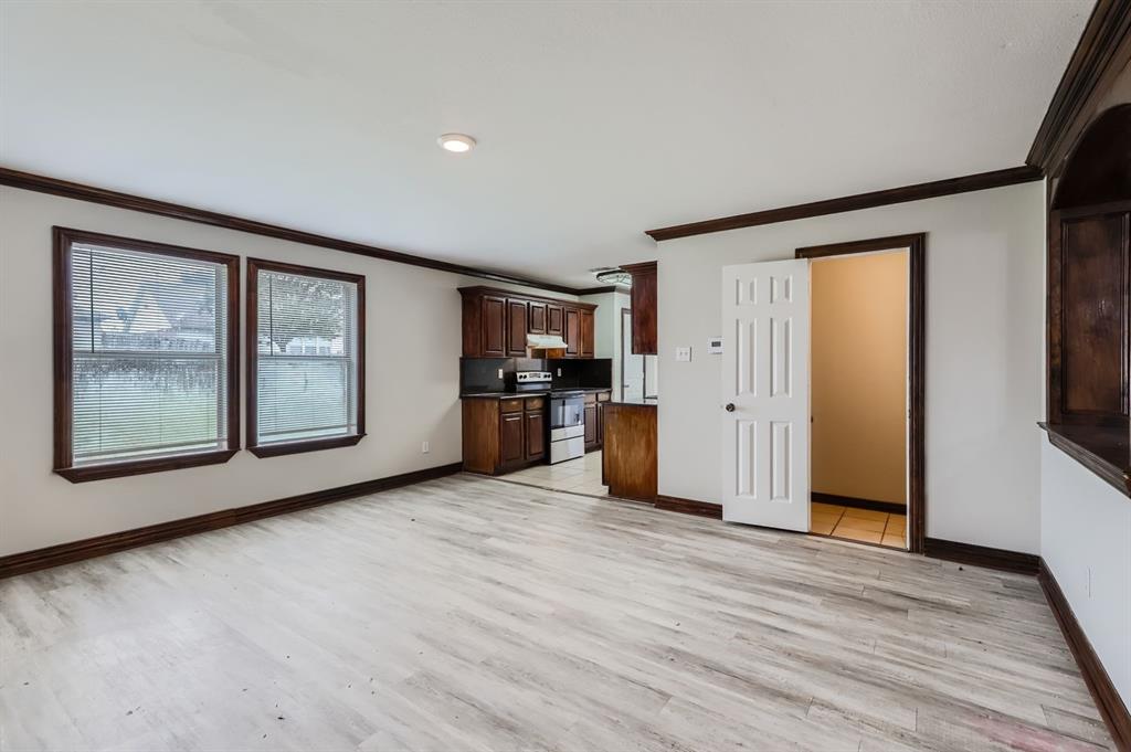 1406 Buckingham Drive Forney, TX 75126 - Photo 11 of 30 a view of a big room with wooden floor and windows