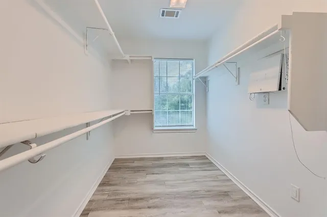 a view of empty room with wooden floor and ceiling fan