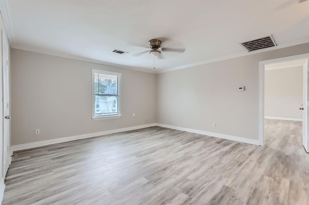 1406 Buckingham Drive Forney, TX 75126 - Photo 15 of 30 an empty room with wooden floor ceiling fan and windows