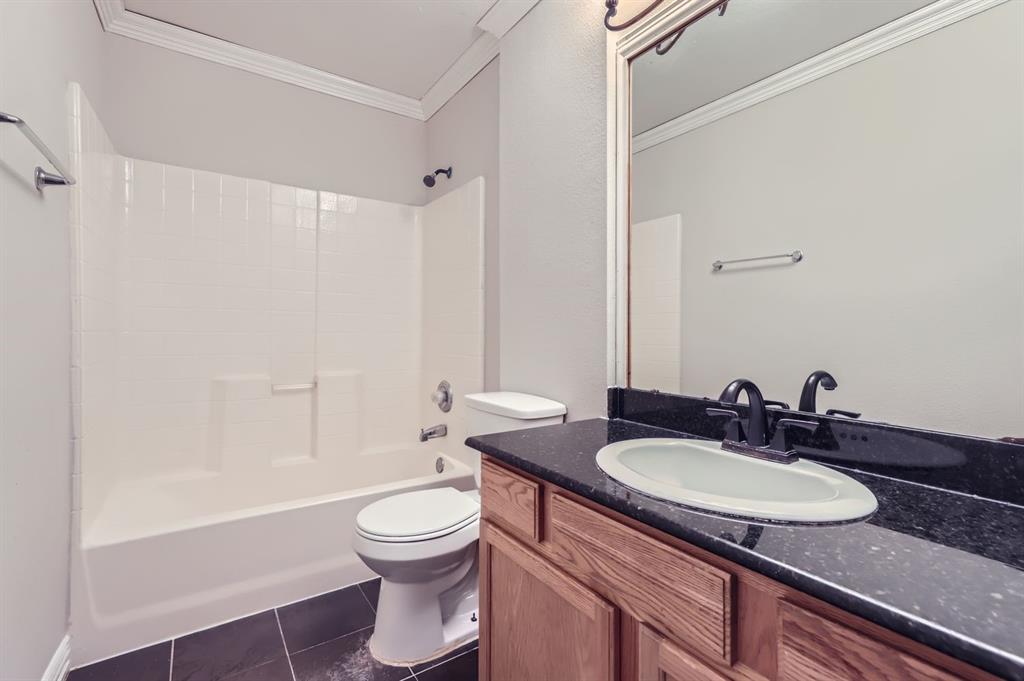 1406 Buckingham Drive Forney, TX 75126 - Photo 16 of 30 a bathroom with a granite countertop sink toilet a mirror and shower
