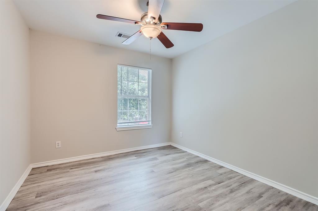 1406 Buckingham Drive Forney, TX 75126 - Photo 17 of 30 an empty room with wooden floor fan and windows