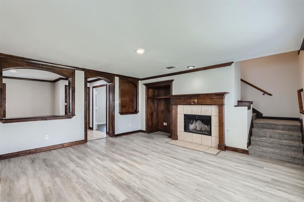 1406 Buckingham Drive Forney, TX 75126 - Photo 6 of 30 a view of an empty room with wooden floor fireplace and a window