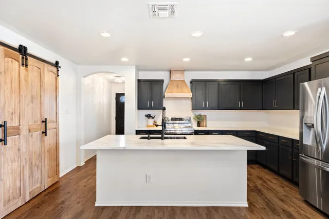 a kitchen with kitchen island stainless steel appliances a sink and a counter top space
