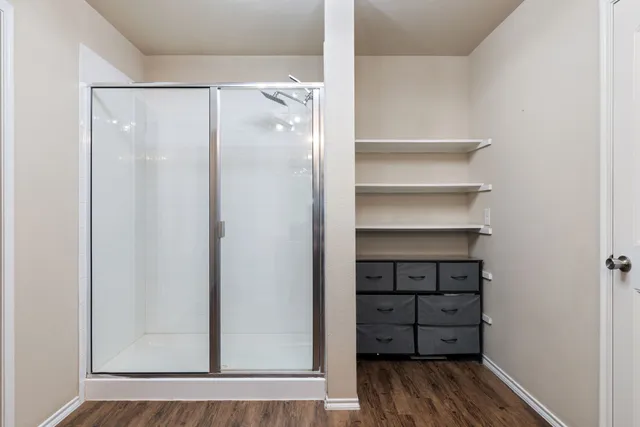 a view of walk in closet with empty racks
