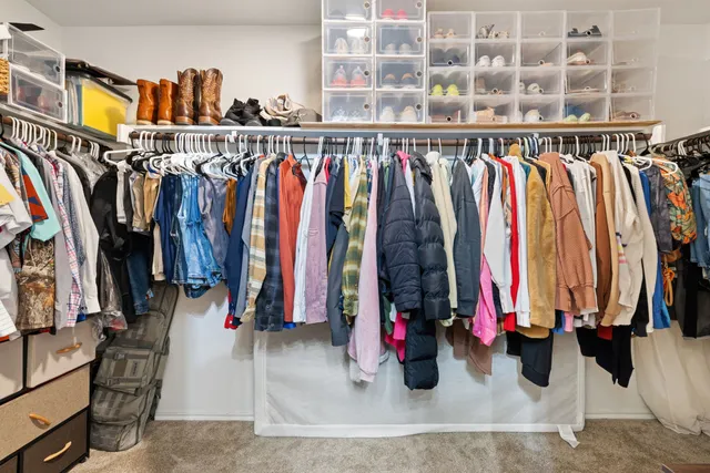 a view of walk in closet with clothes and shoes