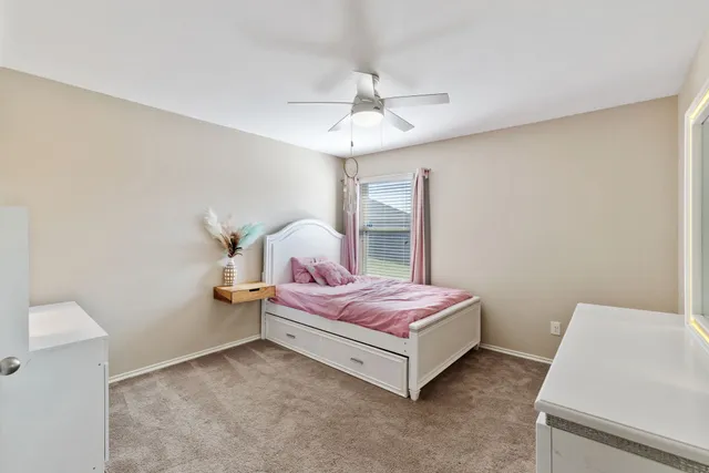 a spacious bedroom with a bed and a chandelier