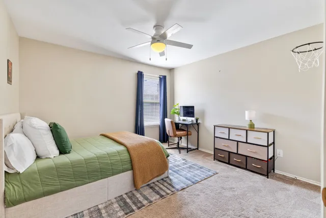 a spacious bedroom with a bed a couch and a chandelier