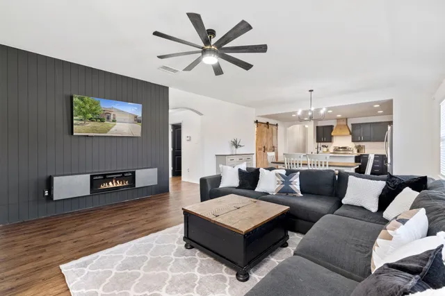 a living room with furniture and a wooden floor