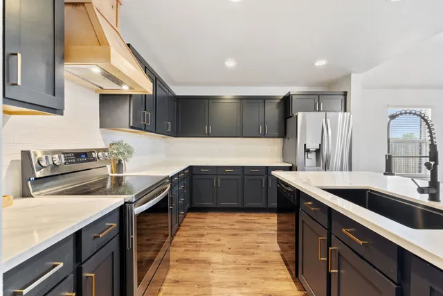 a kitchen with stainless steel appliances granite countertop a sink stove and refrigerator