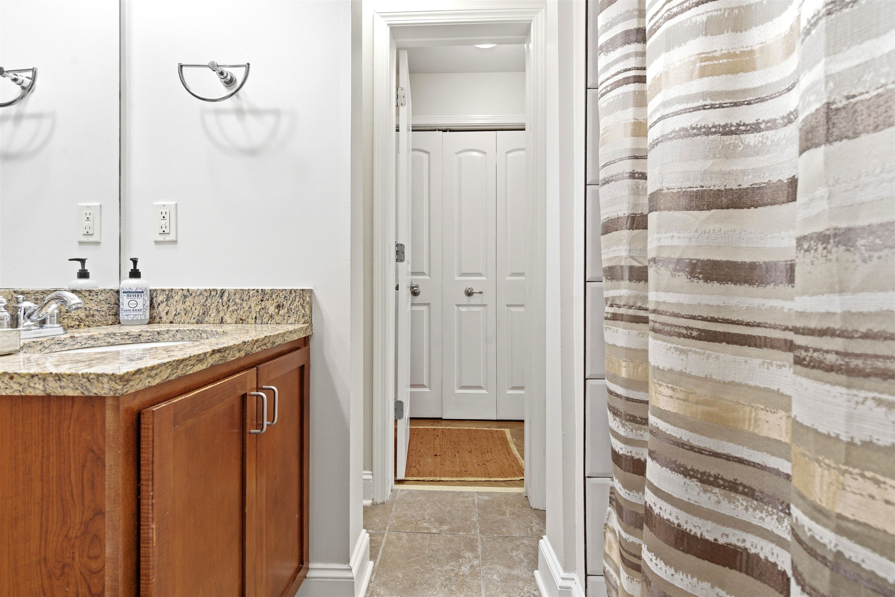 75 Shoemaker Court, Unit 105 Memphis, TN 38103 - Photo 11 of 36 a bathroom with a granite countertop sink and a mirror