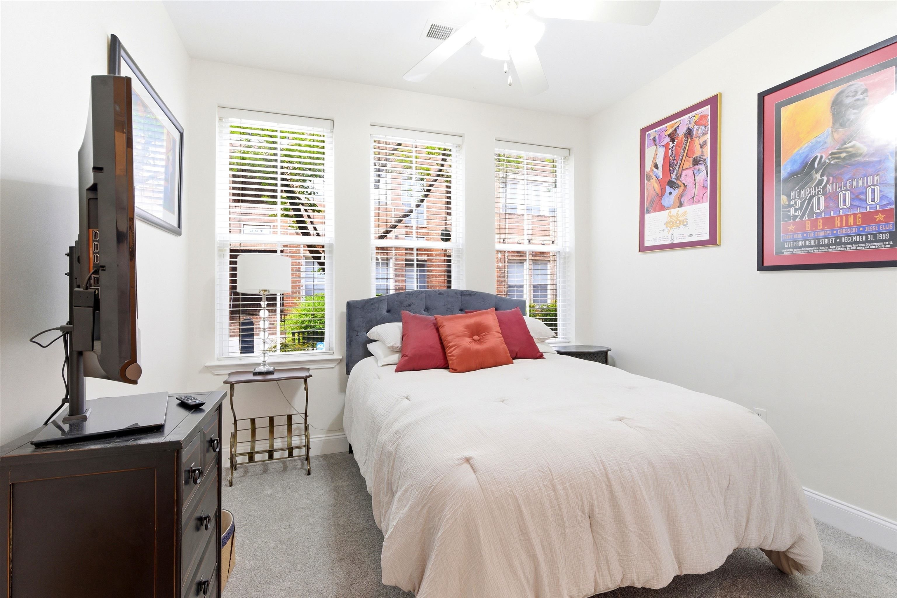 75 Shoemaker Court, Unit 105 Memphis, TN 38103 - Photo 9 of 36 a bedroom with a large bed and a flat tv screen on dresser