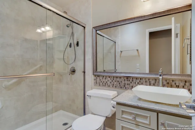 a bathroom with a sink a toilet and shower