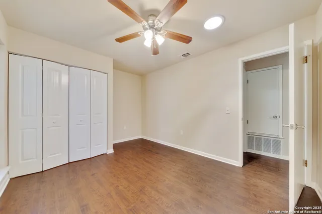an empty room with fan and entrance