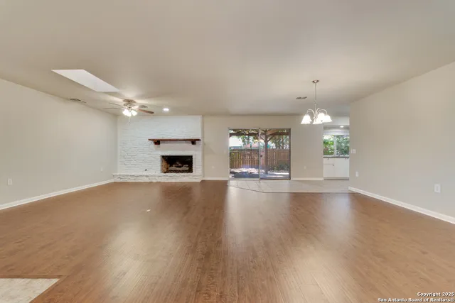 an empty room with fireplace and wooden floor