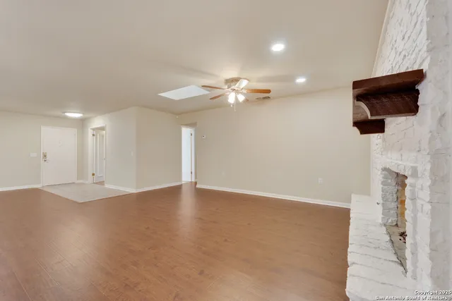 an empty room with wooden floor and chandelier