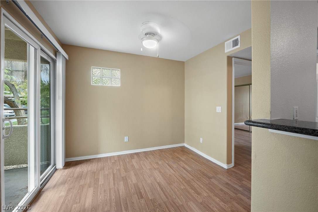 3145 East Flamingo Road, Unit 1055 Las Vegas, NV 89121 - Photo 12 of 40 A well-lit interior offers a view to the outdoors through sliding glass doors, complementing the wood flooring.