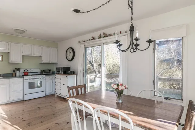 a kitchen with granite countertop a table chairs stove and cabinets